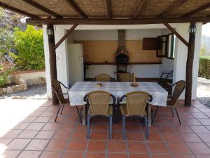 Une table à manger et des chaises sont disponibles sur la terrasse. dans l'établissement Casa Rural El Puerto, à El Chorro