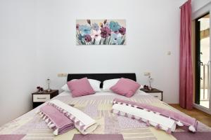 a bedroom with a bed with pink and white pillows at Family apartment in Omiš +90 photos