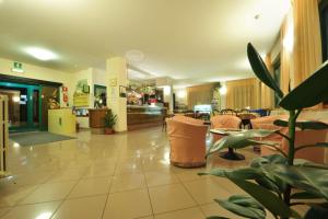 a lobby with a waiting area with chairs and a plant at Hotel Torre in Sondalo