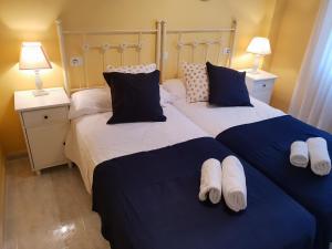 two beds in a bedroom with blue and white sheets at Precioso Apartamento in Peñíscola
