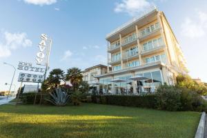 a hotel with a sign in front of it at Savoy Hotel in Marina di Pietrasanta