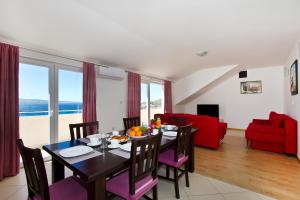 a dining room and living room with a table and chairs at Family apartment in Omiš