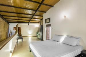 a bedroom with a white bed and a wooden ceiling at Villa 47 Colombo in Pannipitiya