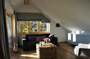 a living room with a couch and a table with flowers on it at dasGams in Gosau