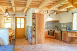 a large kitchen with wooden ceilings and a table at Almchalet Pöllatal in Rennweg