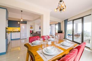 a dining room with a wooden table and red chairs at Villa Spring- Hill Villas Kalkan in Kaş