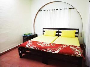 1 dormitorio con 1 cama con colcha roja y blanca en Tagore Homestay Villa Trivandrum, en Trivandrum
