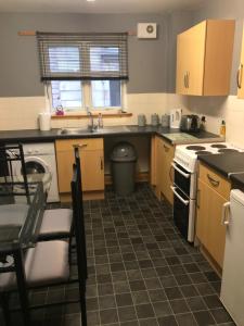 a kitchen with a sink and a stove top oven at 3 coach house balnagown in Tain