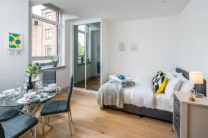 1 dormitorio con cama y mesa de cristal en Regents North London Apartments en Londres
