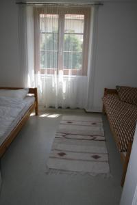 1 dormitorio con cama, ventana y alfombra en Maison d'Alsace, en Breitenbach-Haut-Rhin