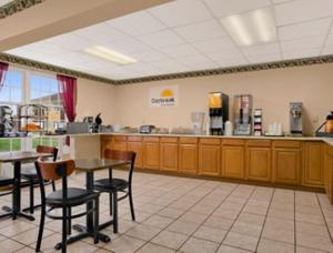 a restaurant with tables and chairs in a cafeteria at Days Inn by Wyndham Madisonville in Madisonville