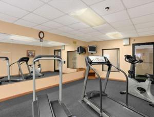 a gym with several treadmills in a room at Days Inn by Wyndham Madisonville in Madisonville