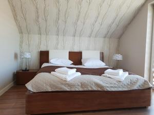 a bedroom with a large bed with two pillows on it at Hotel Pod Strzechą in Kielce