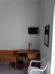 um quarto com uma secretária e uma televisão na parede em Hotel Torre em Sondalo