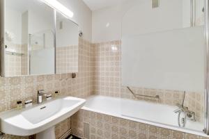 Un baño con un lavabo blanco y una bañera. en Stylish Loft in Saint-Germain Des Près, en París 25 fotos más