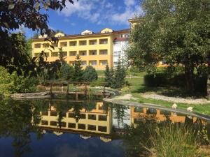 a building with a reflection in the water at Wellness & Spa Apartments Lipno - Frymburk in Frymburk