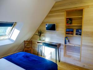 a bedroom with a bed and a desk and a tv at Chambre d'hôtes - B&B Sarzeau in Sarzeau