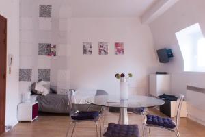 sala de estar con mesa de cristal y sillas en Les studios de la grand Place en Tournai