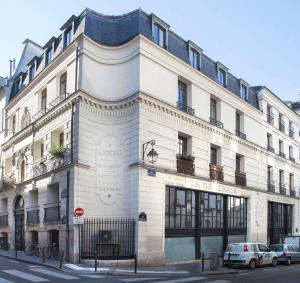 un gran edificio blanco en la esquina de una calle en Sweet Home Paris Apartment, en París