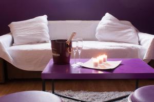 - une table basse violette avec une bougie et une assiette de bougies dans l'établissement Les studios de la grand Place, à Tournai