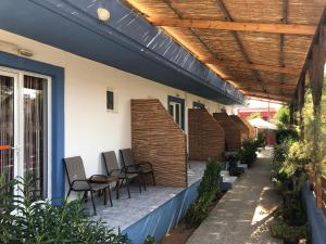 a patio with chairs and awning on a house at Kedros Rooms in Prasonisi