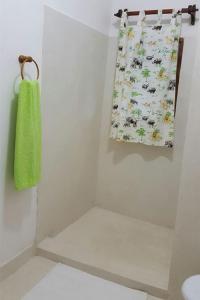 a bathroom with a towel hanging on the wall at Simba House in Watamu