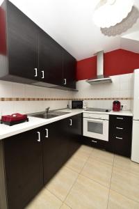 una cocina con armarios negros y electrodomésticos blancos en Ayita House en Arrecife