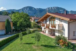 ein Haus mit Garten und Bergen im Hintergrund in der Unterkunft Breitenhof - Haus Breiten in Angath