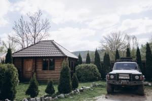 um camião estacionado em frente a uma cabana de madeira em Girskyi Kut em Kuty