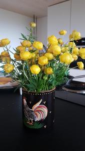 um vaso cheio de flores amarelas num balcão em b&b krättli em Eggiwil