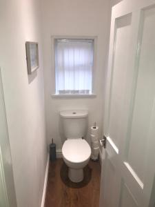 a white toilet in a bathroom with a window at Cornwall Apartments in Blackpool