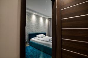Schlafzimmer mit einem Bett und einer Tür, die in ein Zimmer führt in der Unterkunft JAB Apartments Panoramika Business & Family in Stettin