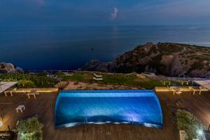 a large swimming pool with a view of the ocean at Faro Capo Spartivento in Chia