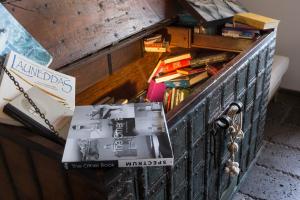 a wooden box filled with books and a pile of books at Faro Capo Spartivento in Chia