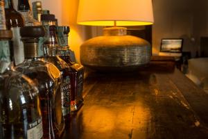 a bottle of alcohol and a lamp on a wooden table at Faro Capo Spartivento in Chia