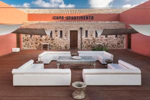 a living room with white couches and a brick building at Faro Capo Spartivento in Chia