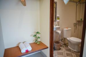 La salle de bains est pourvue de toilettes et de serviettes sur une table. dans l'établissement Deko House, à Ubud