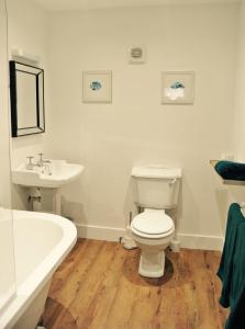 a bathroom with a toilet and a sink and a tub at Rooms at Martha Jones in Pwllheli