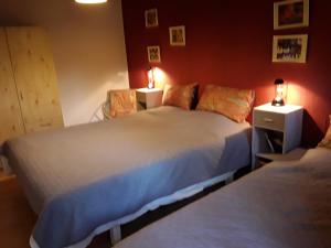 a bedroom with two beds and two lamps on tables at La Petite Maison in Six Planes