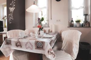 mesa de comedor con sillas blancas y mantel en Ferienwohnung Keull, en Coesfeld