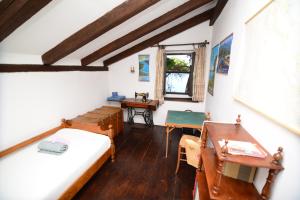 a room with two beds and a desk and a window at Villa Avelina in Mali Lošinj