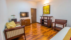 a living room with a couch and a television at Pearl Royal Hotel, Colombo in Colombo