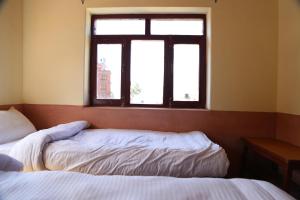 1 dormitorio con 2 camas y ventana en Himalayan Paradise, en Muktināth