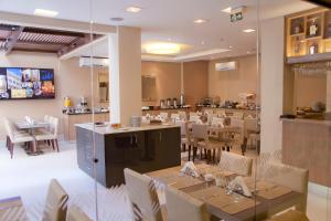 a dining room with tables and chairs in a restaurant at Grande Hotel Petrópolis in Petrópolis