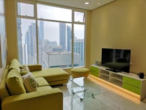 Soho Suites Klcc By Pnut KLCC VIEW في كوالالمبور: غرفة معيشة مع أريكة وتلفزيون بشاشة مسطحة