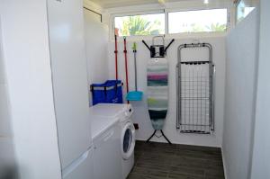 een badkamer met een wastafel en een wasmachine bij The Peaches Bungalows 45 & 46 in Maspalomas
