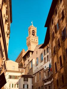 un edificio alto con una torre de reloj encima en signoria suite, en Florencia