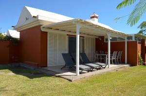 a patio with chairs and a pergola on a house at The Peaches Bungalows 45 & 46 in Maspalomas