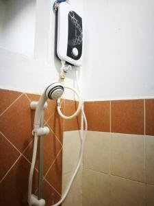 a hair dryer on the wall of a bathroom at One Homestay @ Kirana in Kuala Berang