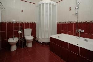 y baño con aseo, bañera y lavamanos. en Lira Hotel, en Saratov